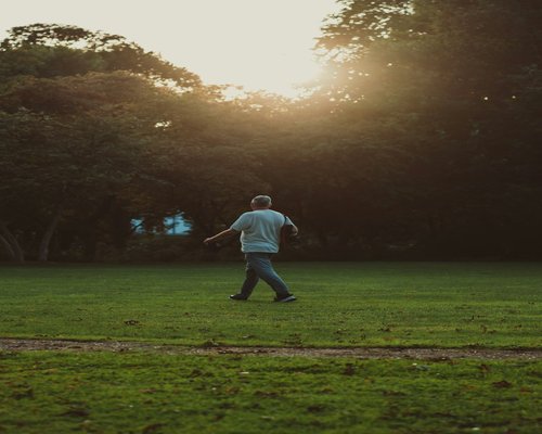 Person doing light walking exercise in a green park